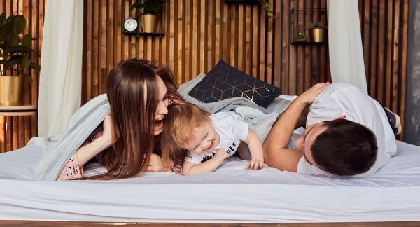 hotéis para família - uma família brincando na cama de um dos melhores hotéis de Portugal